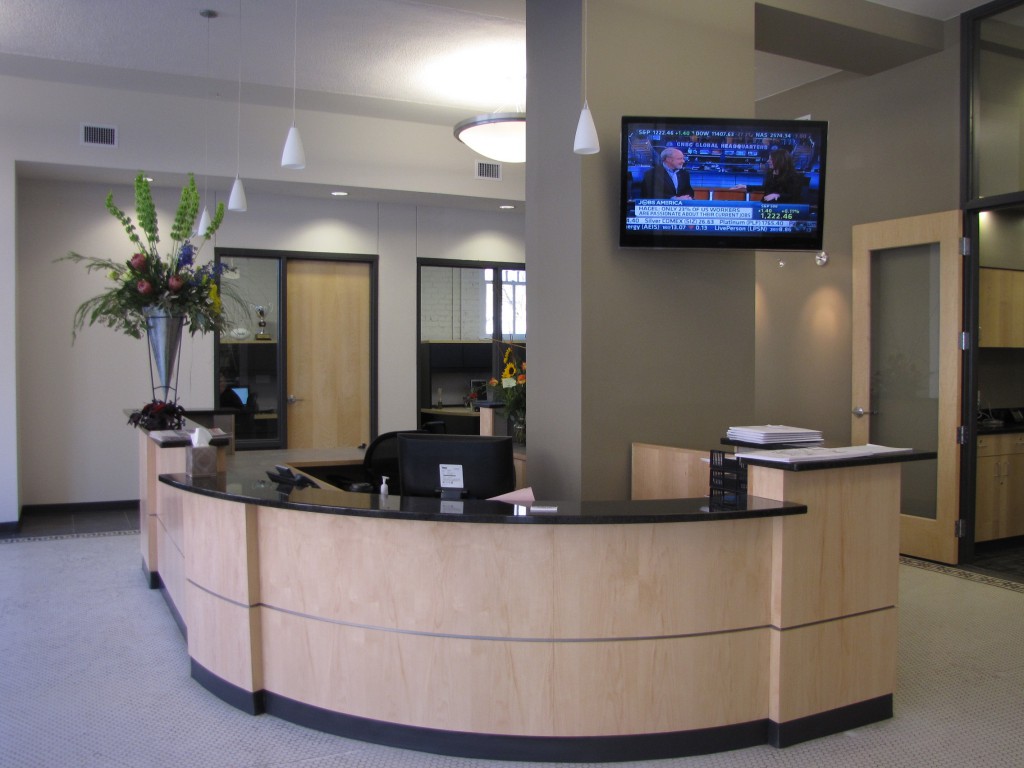 Office lobby cabinetry with custom curved reception desk and modern décor.