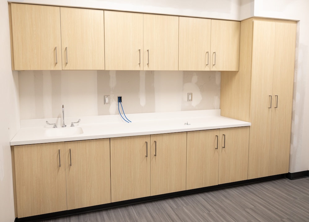 Light wood cabinetry with integrated sink in OrthoNebraska clinic